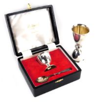 An Elizabeth II silver egg cup and spoon, boxed, Sheffield 1976, and a silver double ended goose and