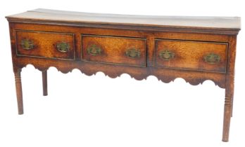A late 18thC oak dresser, with three drawers, above a shaped apron, raised on ring turned legs, 76cm