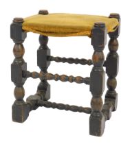 A 19thC oak stool, in the 17thC style, with a yellow dralon seat, raised on turned supports united b