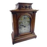 A late 19thC/early 20thC oak cased mantel clock, with a silvered Arabic numeric dial, with chime and