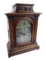 A late 19thC/early 20thC oak cased mantel clock, with a silvered Arabic numeric dial, with chime and