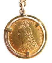 A Victorian shield back gold sovereign 1892, in halo mount and yellow metal chain, 12.1g all in.