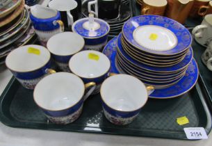 A porcelain part tea service, decorated with flowers against a cream ground with a blue border with