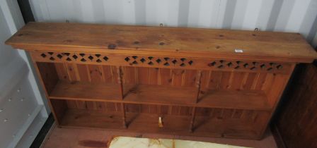 A pine hanging wall shelf, the moulded top above a pierced section, the base with two shelves suppor