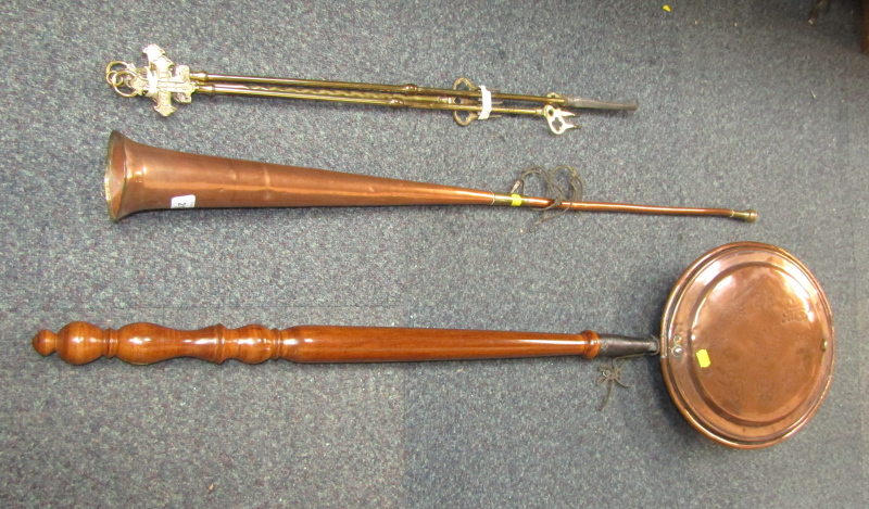 A copper warming pan, together with a copper hunting horn and brass fireside implements.