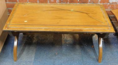 A coffee table, the top inlaid with brass banding, on X shaped supports, united by turned stretcher,