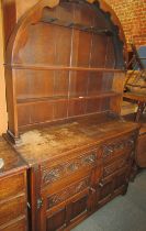 An oak dresser, with arched top, the base with two drawers above two cupboards, 177cm high, 123cm wi