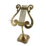 A small brass table top music stand, the lyre rest on a square base with canted corners, 50cm high.