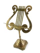 A small brass table top music stand, the lyre rest on a square base with canted corners, 50cm high.