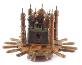 An early to mid 20thC Indian teak cutlery set, of wheel form, the top decorated with a temple, possi