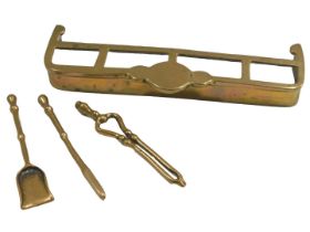 A miniature brass fireside curb set, and three miniature implements, the curb 16cm wide.