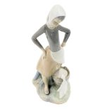 A Lladro porcelain figure modelled as a girl with milk pail, printed marks, 23cm high.