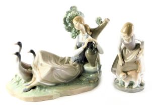 A Lladro porcelain figure group, modelled as a lady seated leaning against tree beside two handled v
