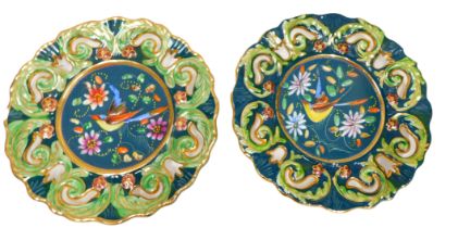 A pair of Belgian Faience and enamelled wall plates, with pierced borders and central ornithological