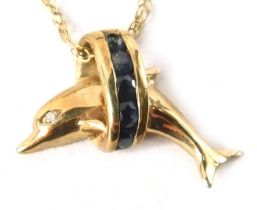 A 9ct gold pendant and chain, the pendant formed as a leaping dolphin, set with blue central stones