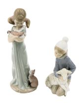 Two Lladro porcelain figures modelled as a boy seated with lamb, 15cm high, and young girl holding k