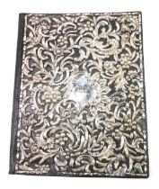 A late 19thC black leather and silver desk blotter, embossed with floral scroll work and centred by