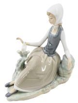 A Lladro porcelain figure group modelled as a young woman seated beside dove, printed marks, 17cm hi