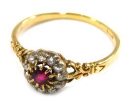 An Edwardian dress ring, formed as a cluster set with central garnet in claw setting surrounded by o