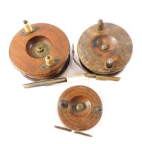A mahogany and brass Star fishing reel, with bone handles, 10cm diameter, and two others.