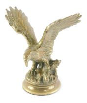 A brass model of an eagle, on a circular base, 25cm high.