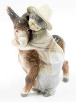 A Lladro porcelain figure group modelled as a boy hugging donkey, printed marks, 21cm high.