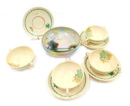 Four Susie Cooper pottery two handled soup bowls and saucers, decorated with leaves against an off w