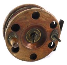 A mahogany brass and polished metal star backed fishing reel, 10cm diameter.