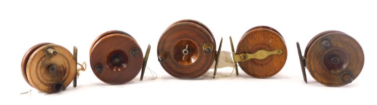 A collection of five early 20thC mahogany brass fishing reels, various sizes, the largest 10cm diame