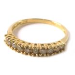 A diamond half hoop dress ring, set with twelve tiny diamonds, each in claw setting, on a thin yello