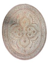 An elaborate pierced and engraved Indian oval copper tray or plaque, decorated with scrolls, stylise