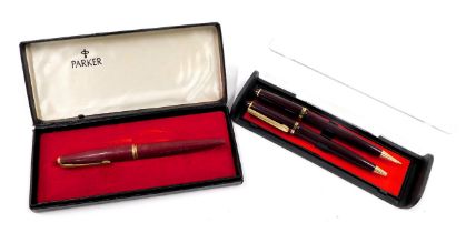 Three pens, comprising a red cased Parker 45 Deluxe fountain pen, and two unbranded ballpoint pens,