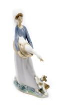 A Lladro porcelain figure modelled as a lady holding goose beside puppy, printed marks, 28cm high.