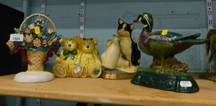 Three painted cast metal doorstops, comprising vase of flowers, duck and cat, together with a bear f