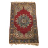 A Kirman red ground rug, with a central floral medallion within repeating floral borders, 152cm x 95