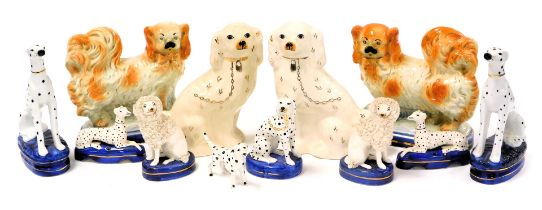 A pair of late 19thC Staffordshire figures of Pekingese, 21cm wide, together with pottery figures of