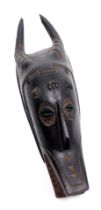 A Burkina Faso or Ivory Coast wooden mask, of a horned figure, 47cm high.