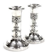 A pair of Victorian loaded silver candlesticks, embossed in the Adam style with Roman lanterns, bows