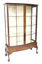 An early 20thC mahogany bow front display cabinet, the outswept pediment over a pair of astragal gla