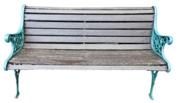 A wooden slatted two seater bench, with green painted cast iron ends, 126cm wide.