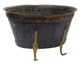 A Victorian copper and brass bound coal bucket, with studded detailing, raised on four scroll legs,