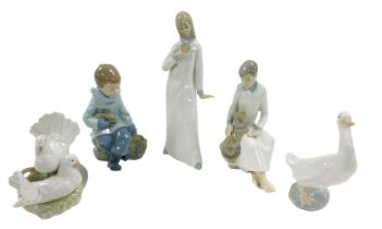 A group of Lladro and other Spanish porcelain figures, including a seated boy with a rabbit, boy