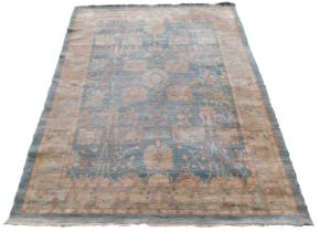 A vintage caucasian blue ground rug, the central field decorated with flowers, within a border of tr