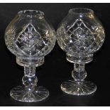 A pair of late 20thC cut glass storm lamp type candle holders, 26cm high.