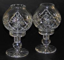 A pair of late 20thC cut glass storm lamp type candle holders, 26cm high.