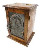 A Victorian Art Nouveau oak and copper panelled smoker's cabinet, with a hinged top and door embosse