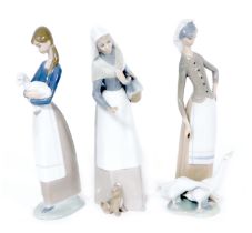 Three Lladro porcelain figures, comprising a lady with a puppy at her feet, and a basket of loaves 2