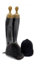 A pair of lady's black leather riding boots, and two riding hats.