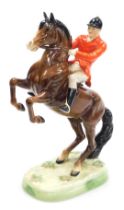 A Beswick pottery figure of a huntsman on a rearing horse, brown gloss, raised on a naturalistic bas