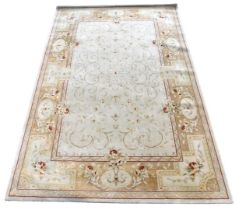 An Aubusson style cream ground rug, decorated centrally with flowers and scrolling leaves, within a